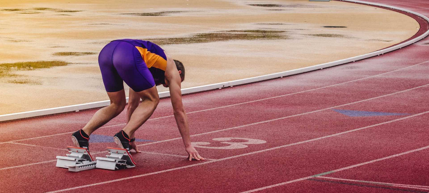 Atleta se prepara para la carrera en una pista ovalada